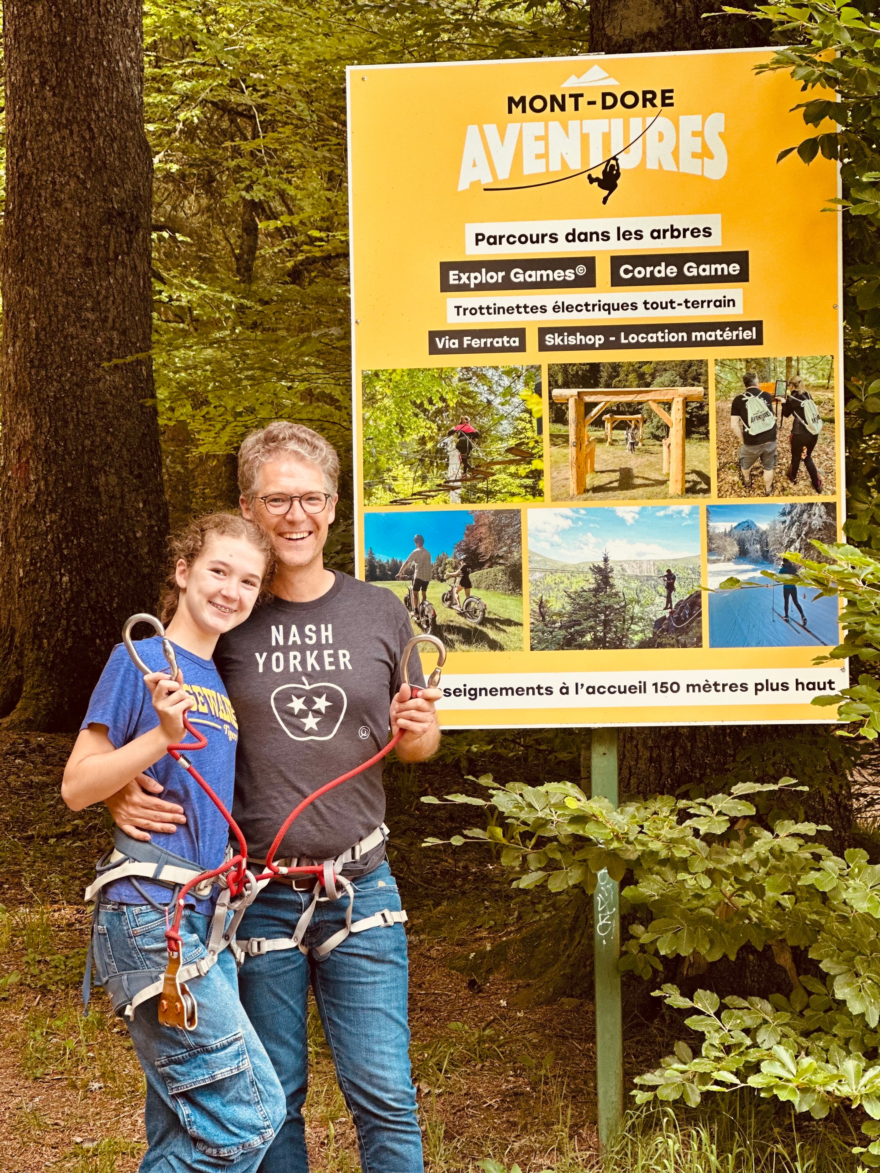 Nicholas McClay and his daughter in climbing harnesses at Mont-Dore Aventures, France